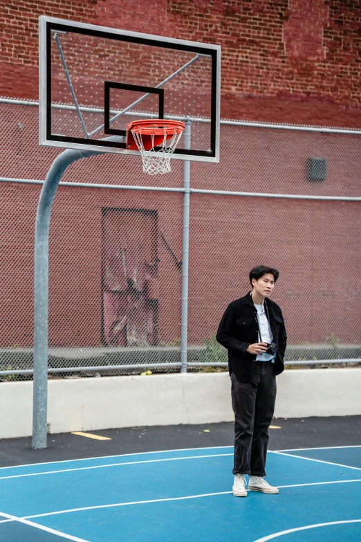 a man standing on a court next to a basketball hoop