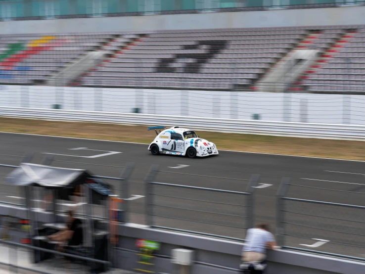 a race car speeding down a track in an arena