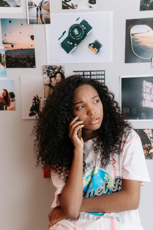 a black woman sitting on a bed while talking on a cell phone