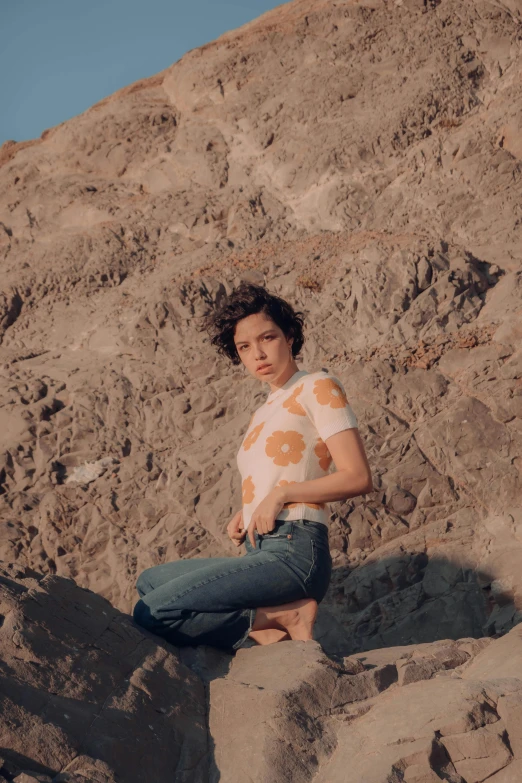 the young woman is posing for a po near a mountain