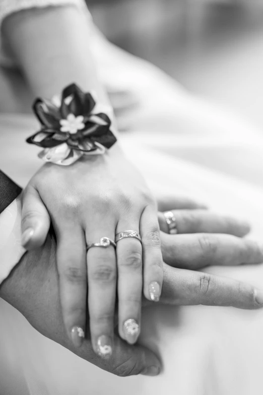 two people are holding hands with rings