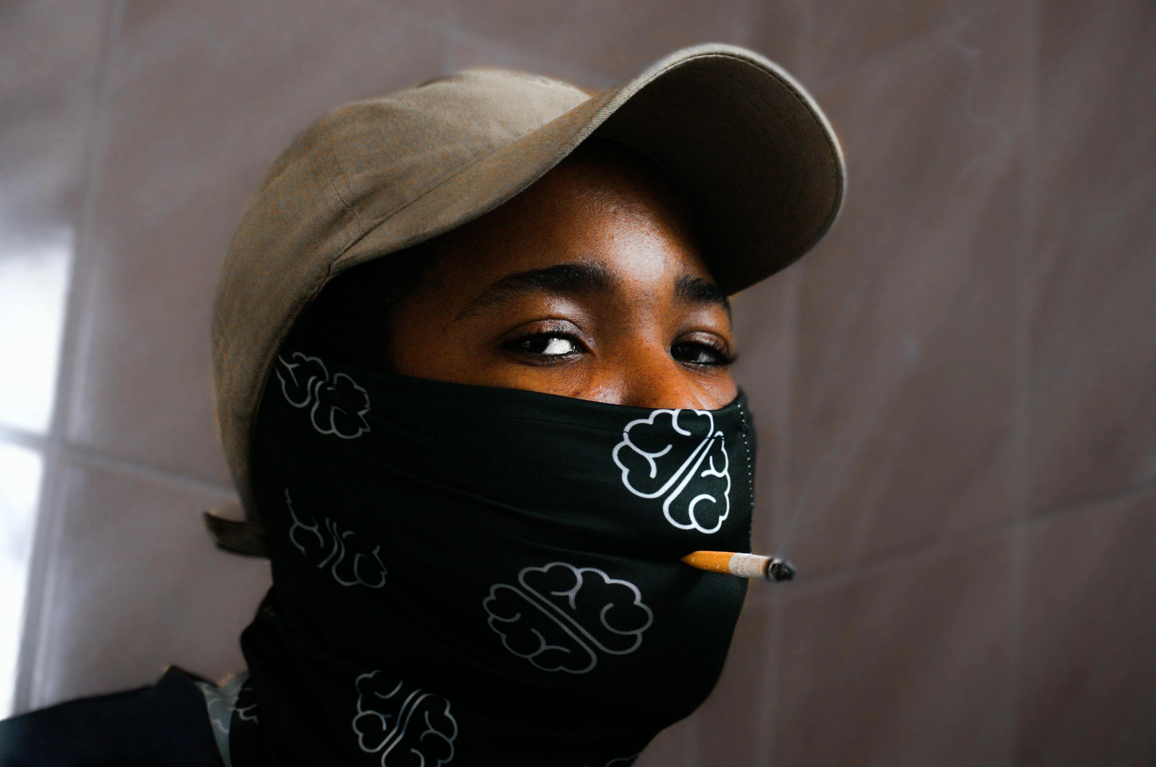 a person wearing a cap, black neck gaiter with flowers on it