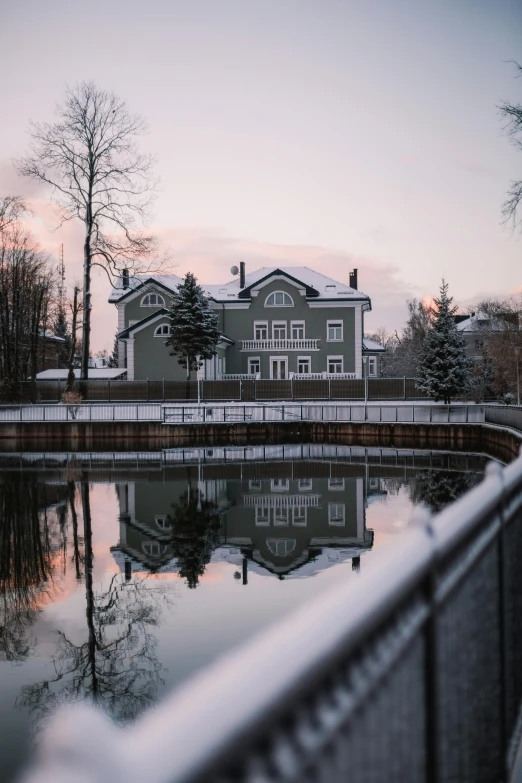 a house next to a water way and a bridge in front