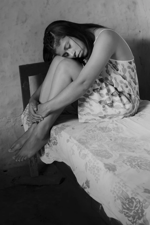 a black and white image of a woman sitting down