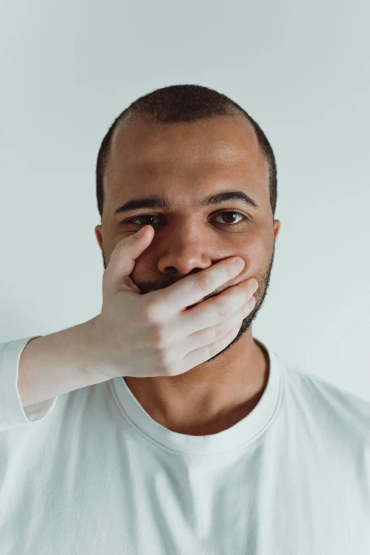 a man covers his mouth with his hands