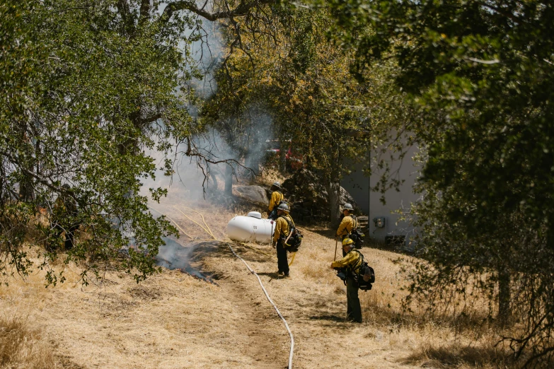 there are two men wearing yellow fire uniforms walking away