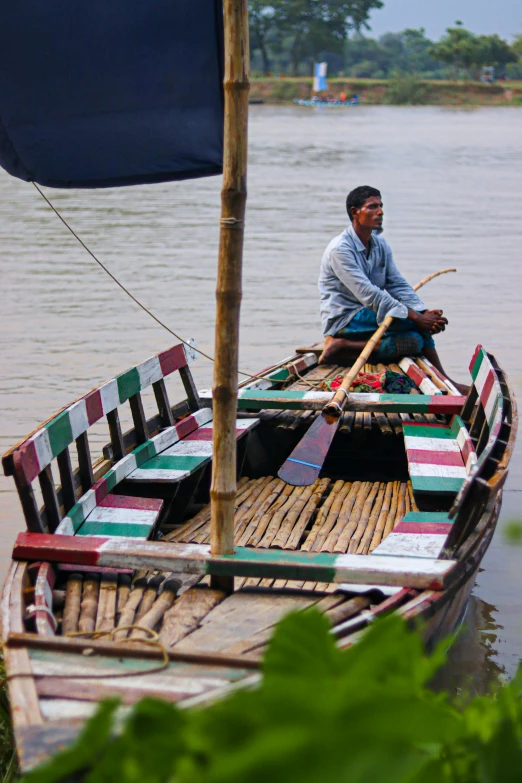 a man is sitting on a boat in the water