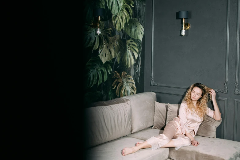 a beautiful young lady sitting on top of a white couch