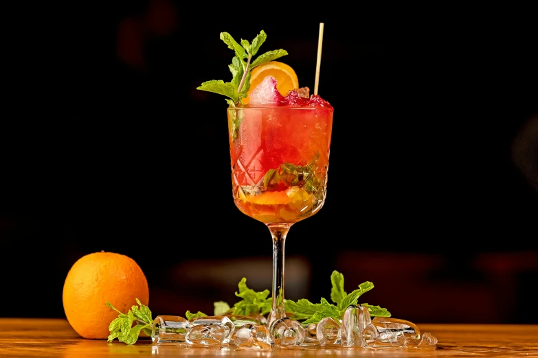 an orange slice sitting on top of a table near a wine glass