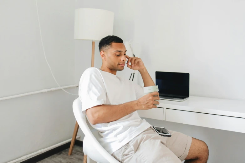 a man is sitting in a chair while on his phone