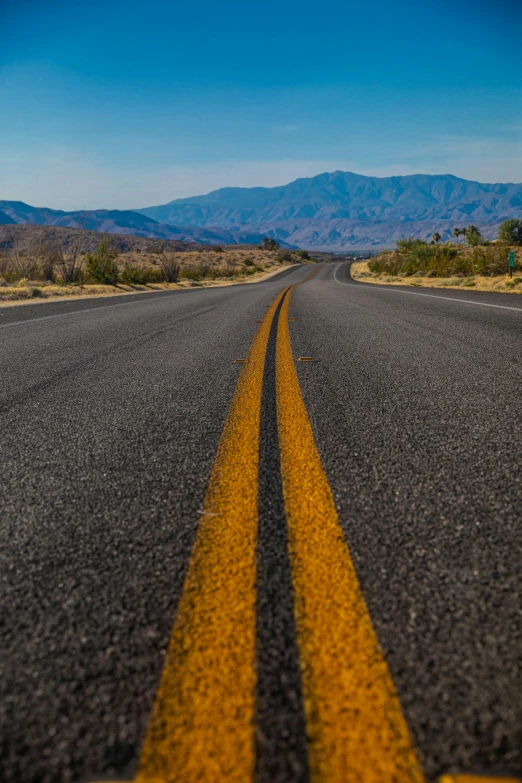 a road in the desert with two yellow lines