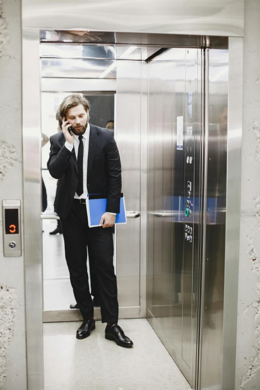 a man in a suit talking on a cell phone