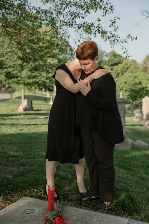 a couple are hugging each other near the gravestones