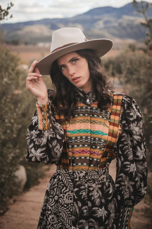 a woman wearing a colorful dress and a hat