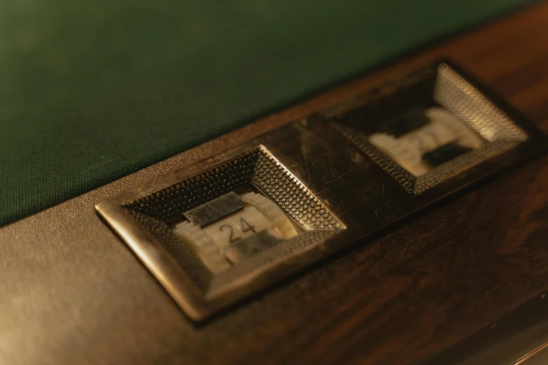 a table topped with two metal plates on top of a green wall