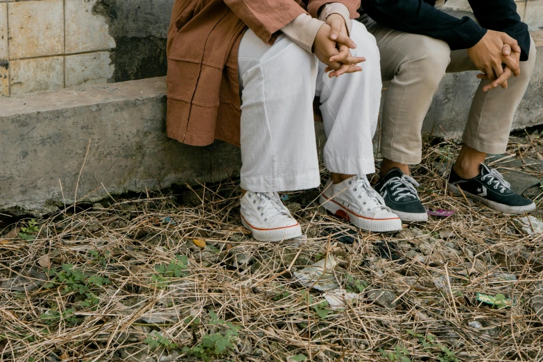 an elderly couple holding hands, as they sit together