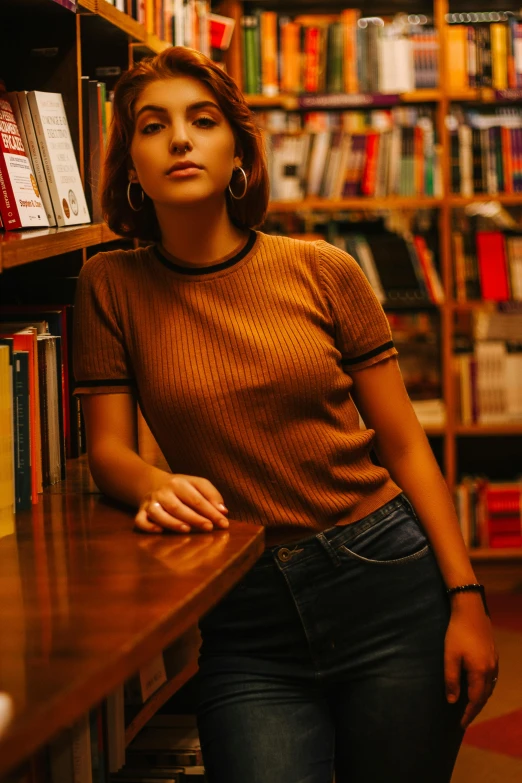 woman leaning against table with books in liry