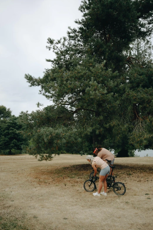 a woman leaning against the back of her bike