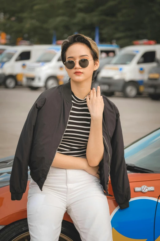 a woman is sitting on the car looking at the camera