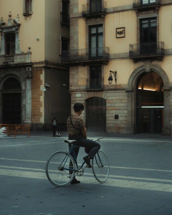 a person on a bicycle in front of an old building