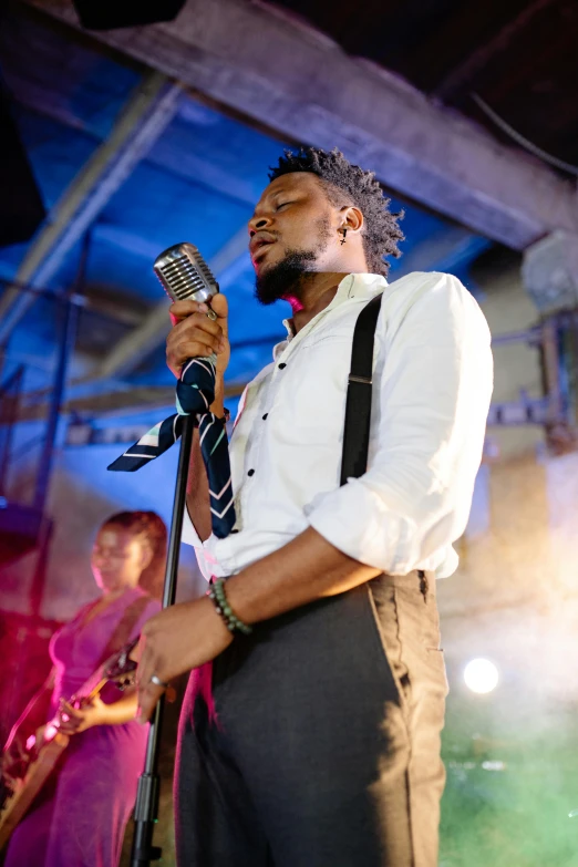 a man singing into a microphone on stage