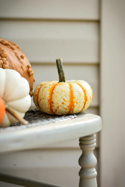 two decorative pumpkins sit on a small table