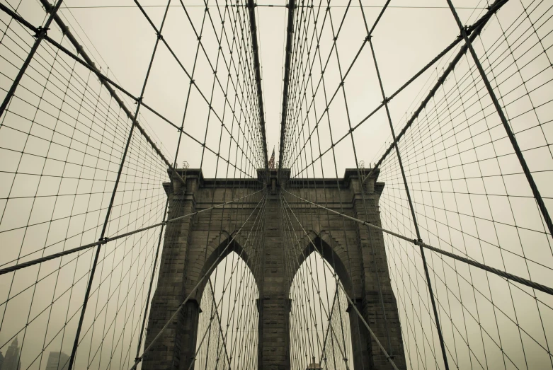 people walking across the brooklyn bridge in new york city