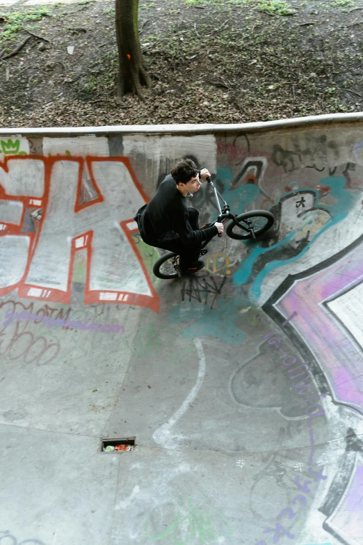 a man doing a trick on a bike in a skateboard park