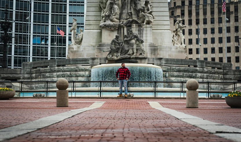 a man standing by a statue and looking at the water