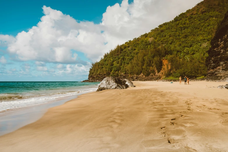 people on the beach near some steep cliffs