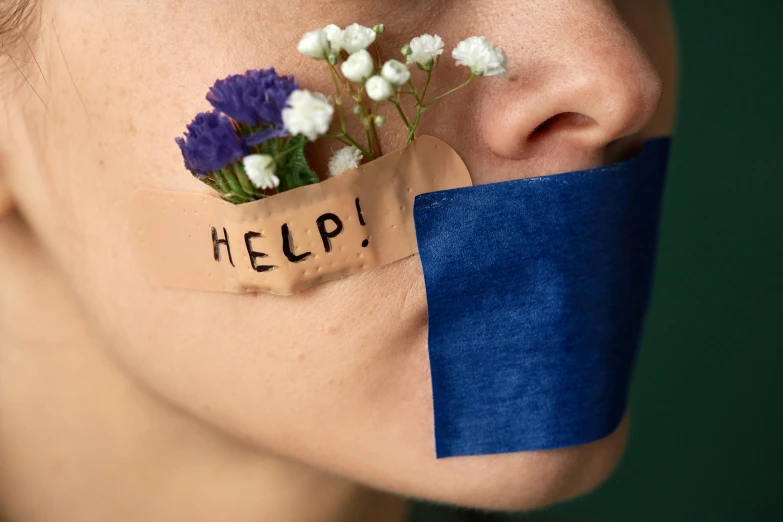 woman's nose with blue ribbon around it and flowers inside of her