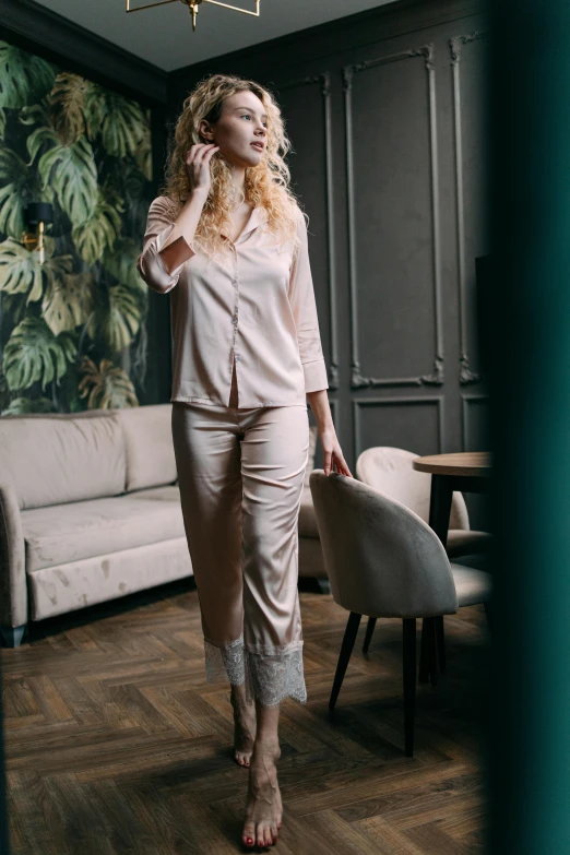 a woman standing in front of a couch and chair wearing high heels