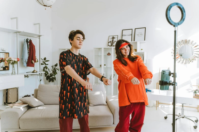 a man standing next to a woman in an orange shirt