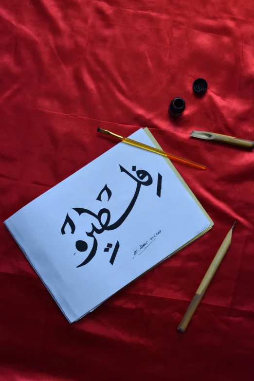 a red table cloth topped with pencils and paper