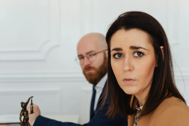 a man and a woman looking at the camera