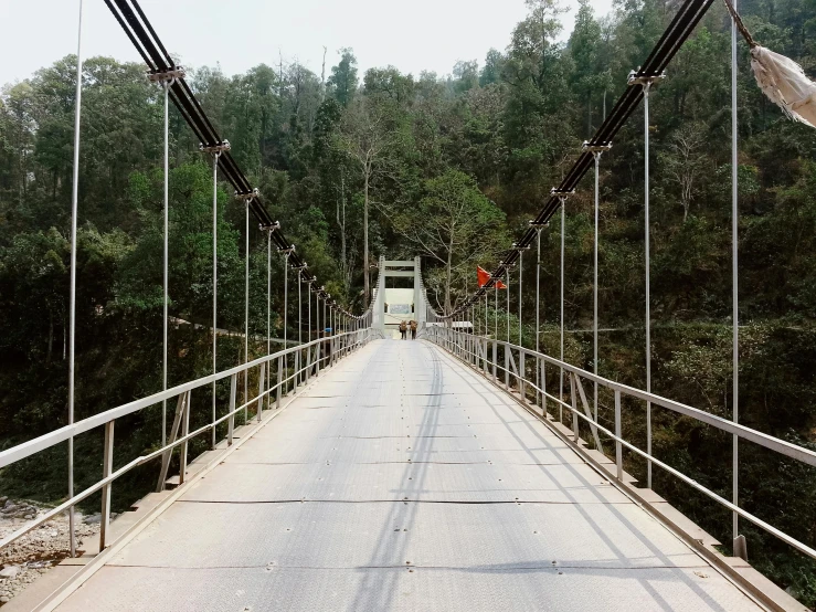 a walkway over a river with many wires