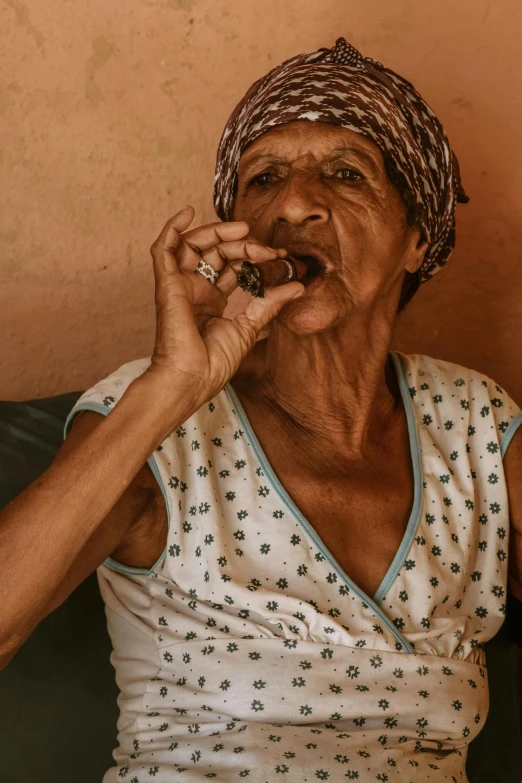 an older woman smokes a cigarette while sitting down