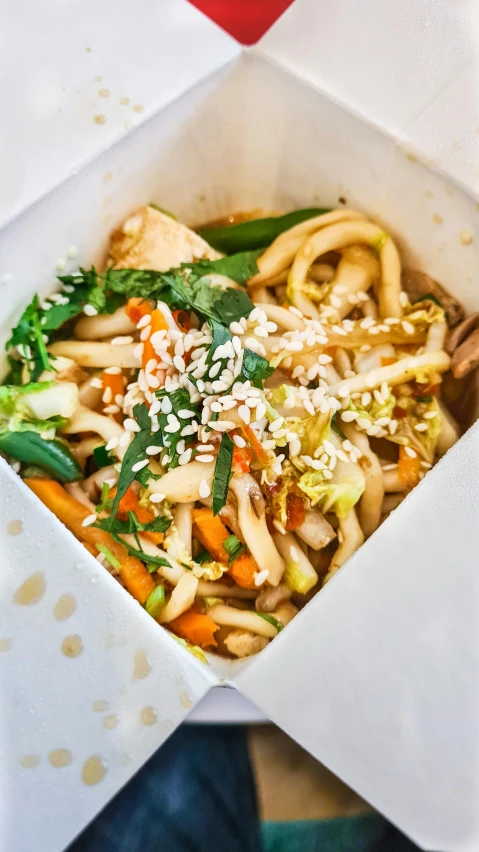 a white plate topped with rice noodles and vegetables