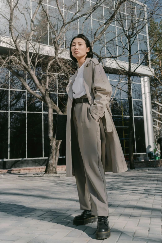 a woman is standing outside in a coat