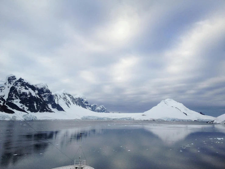 a boat on the water surrounded by mountains