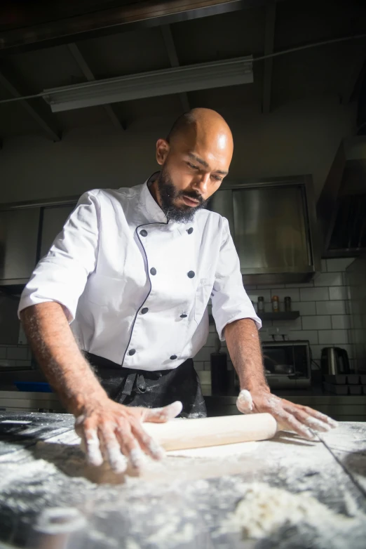 an older man is making dough in the kitchen