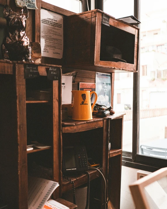 an arrangement of electronics sits atop a desk in front of a window