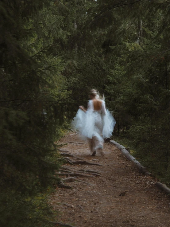 two women in white dresses run down a path
