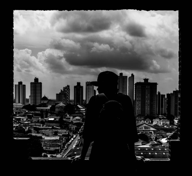 black and white po of two people standing against a cloudy sky