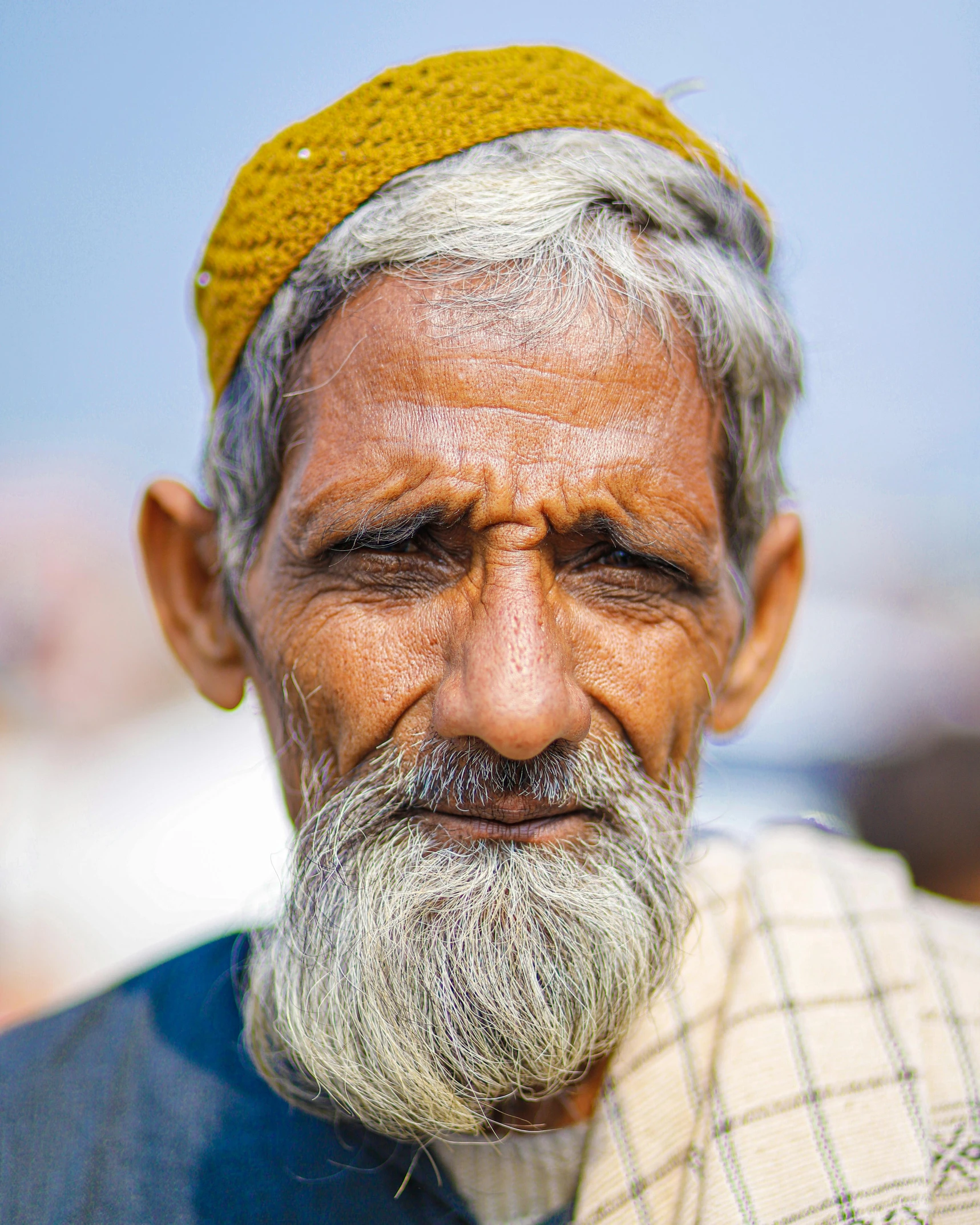 an old man wearing a turban looks into the distance