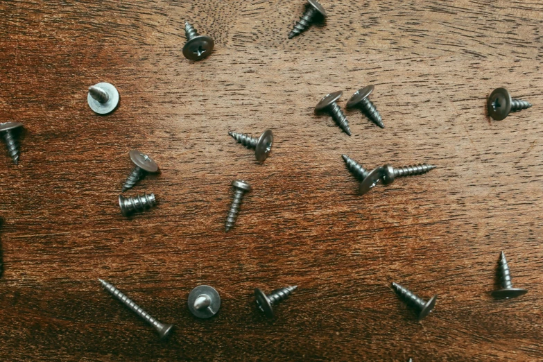 a group of screws arranged on a brown wooden table
