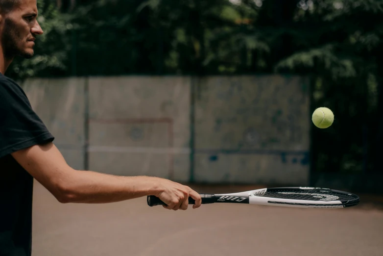 man hitting tennis ball with tennis racquet on court