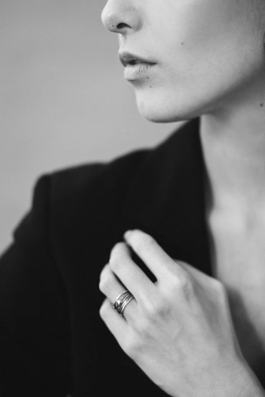 a black and white po of a woman holding a ring on her left hand