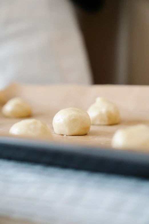 uncooked dough balls sit on a baking sheet