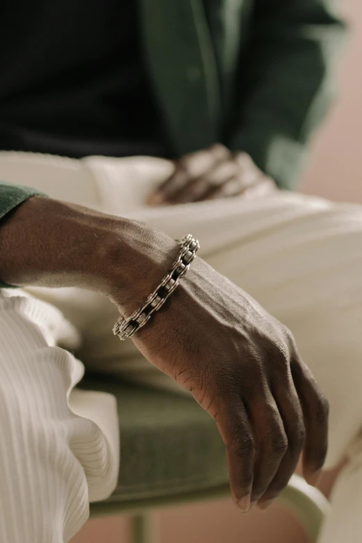 a person's hands holding onto a green and white chair